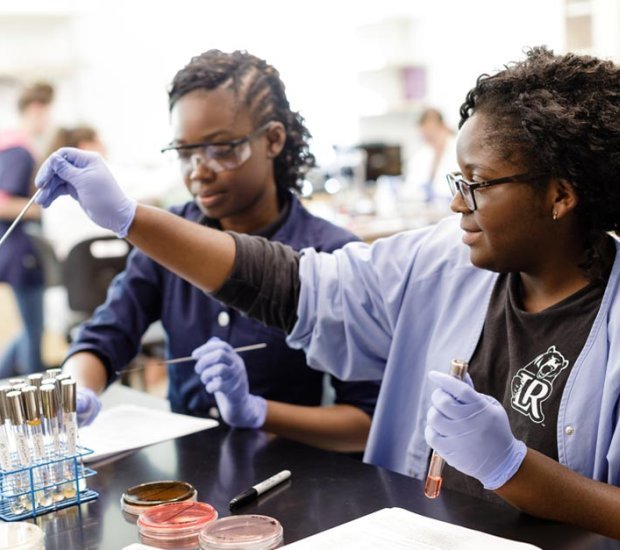 Two students work in chemistry lab on assignment