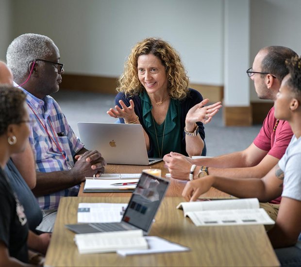 Professor talking with students in seminary classroom during discussion