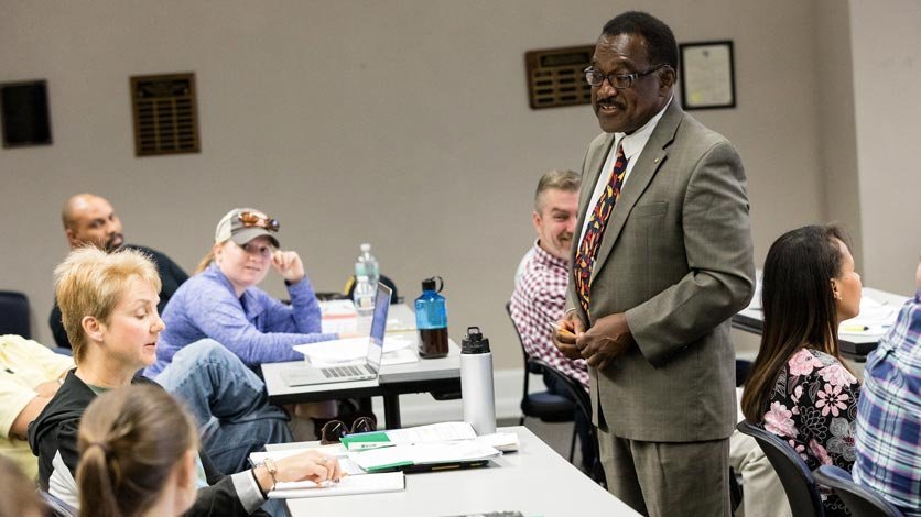 Professor talking with students in classroom