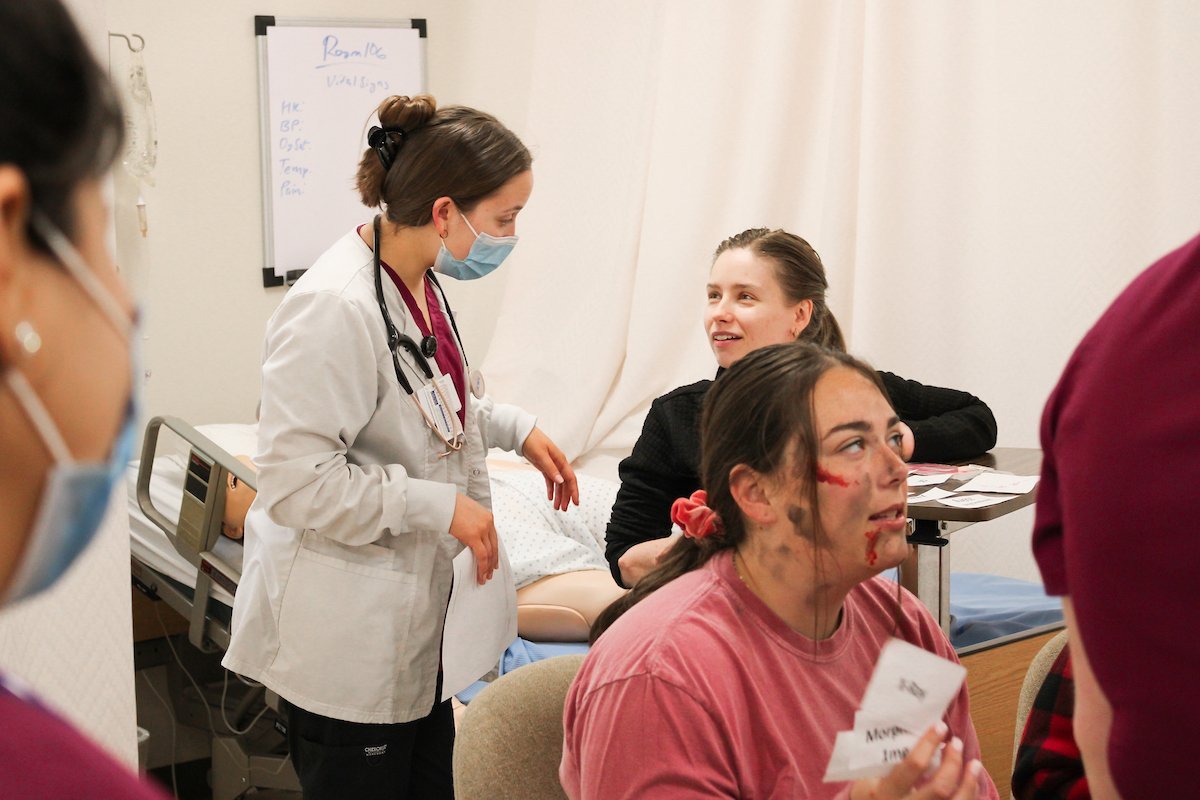 Student nurses work with classmates as part of a disaster simulation