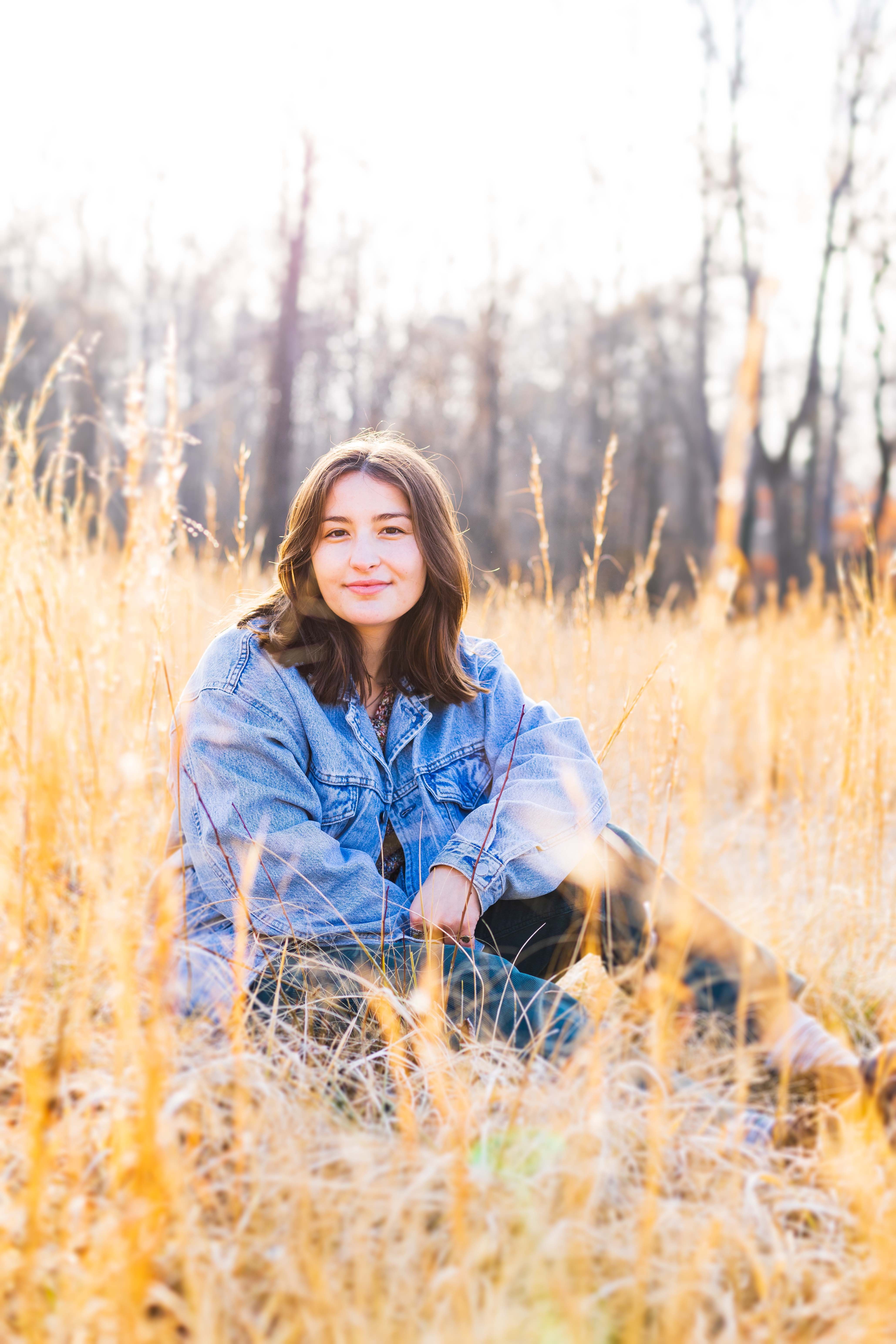 Maggie Keller sits in a field outside