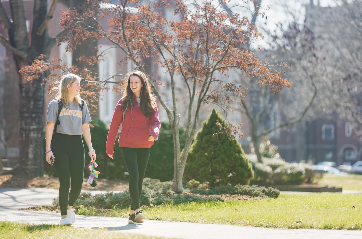 Two female students walk outside on campus