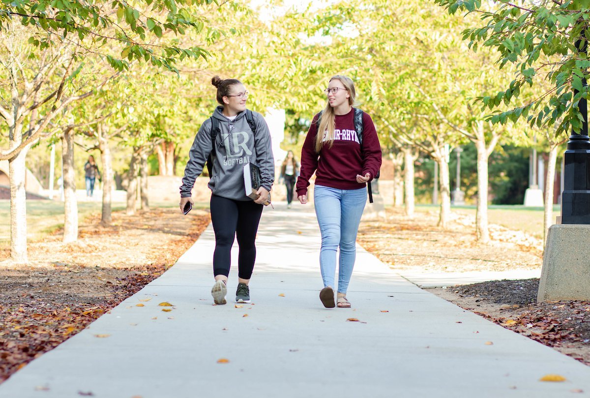 Two students walk and chat outside