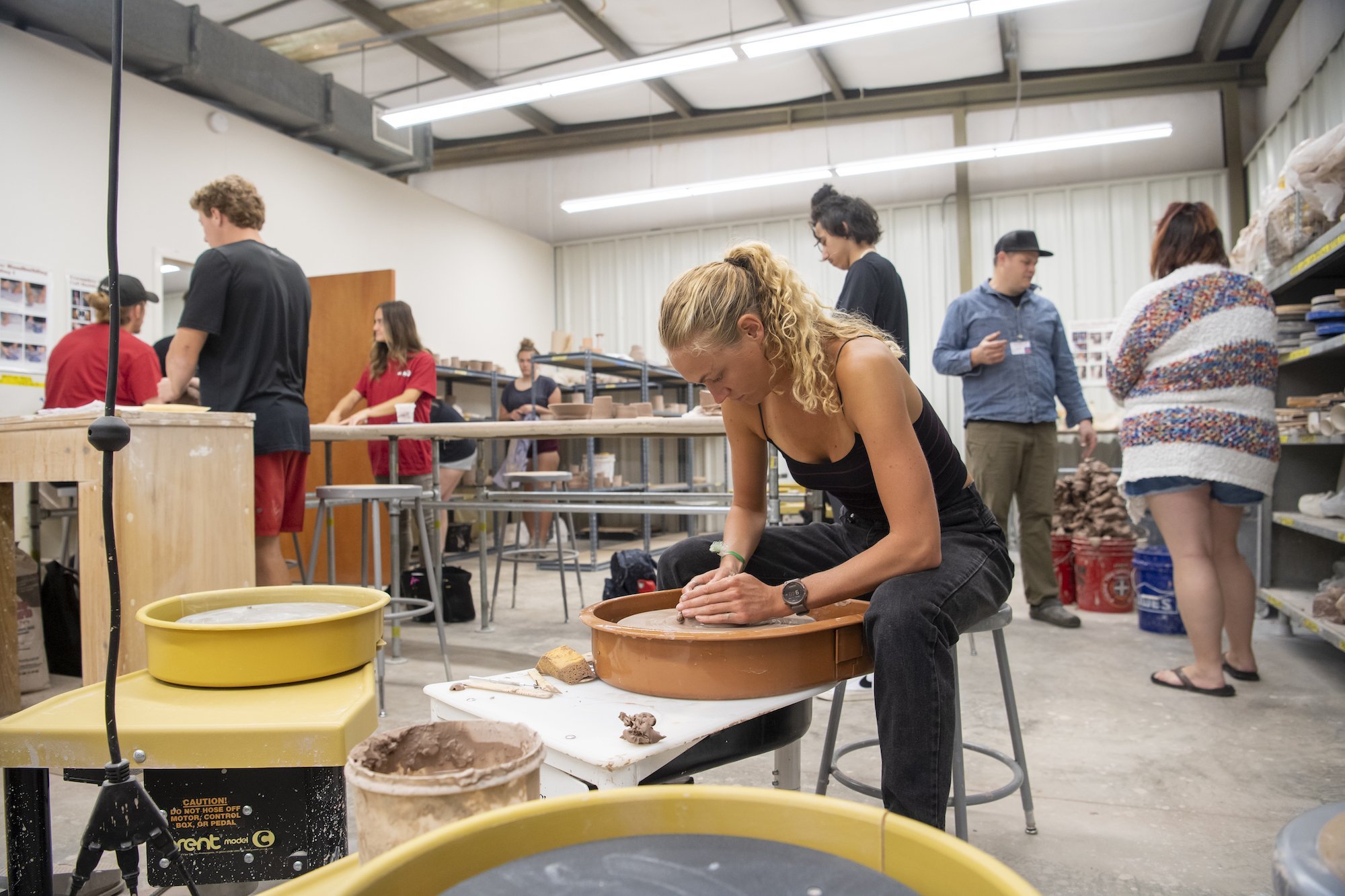 Nanette Nikolajsen molds a pot in a ceramics class