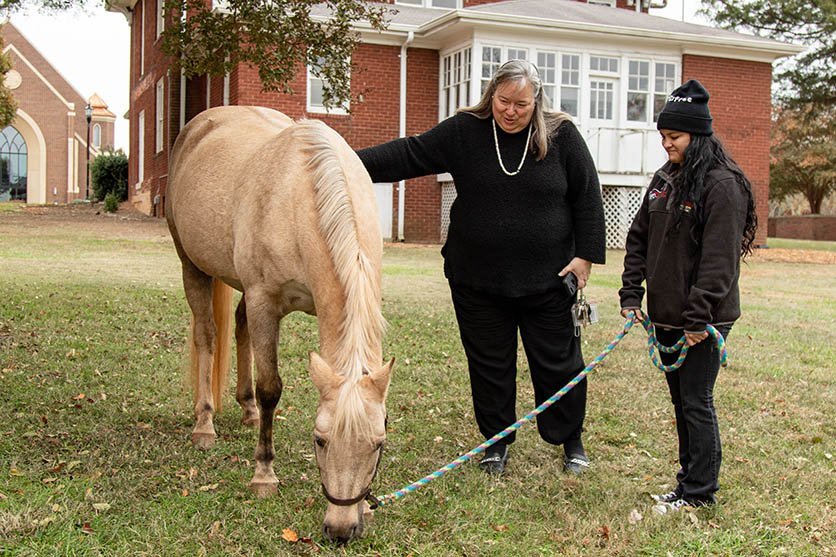 Dean Katie and a horse on campus