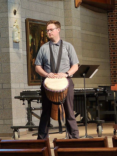 Zachary Bailey performing with a bongo
