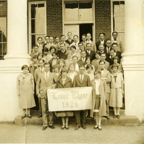 A group of people stand together in an archived 1926 photo