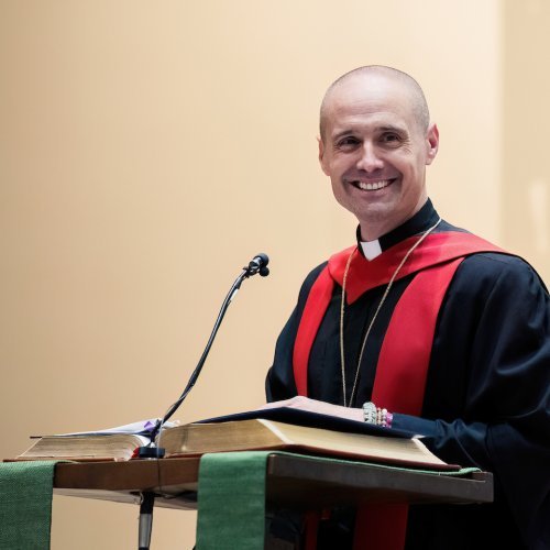 The Rev. Dr. Chad Rimmer stand at a podium