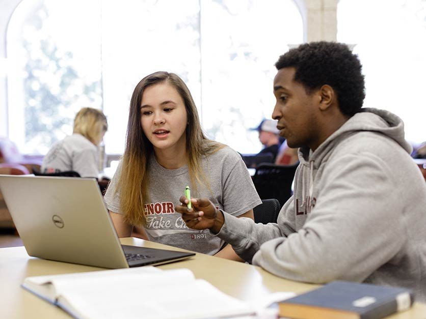 Student assists another student with class assignment 