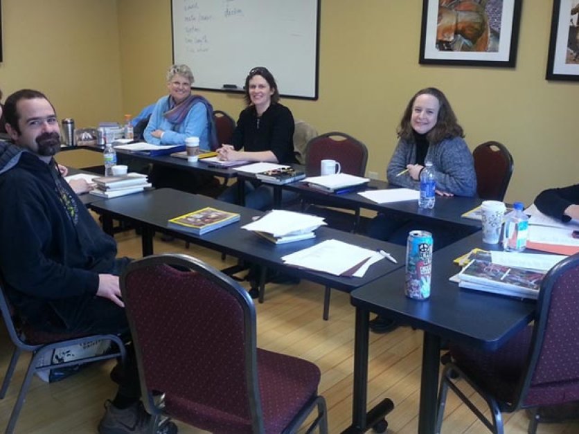 MFA students sitting around table in classroom