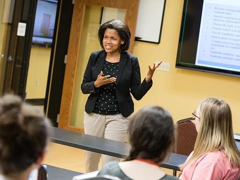 Dr. Kimberly Price teaches in front of a classroom.