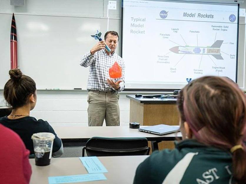 Dr. Knight demonstrating rocket physics in front of class