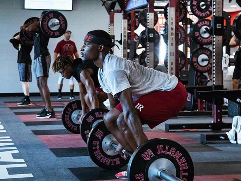 An LR student athlete lifts weights