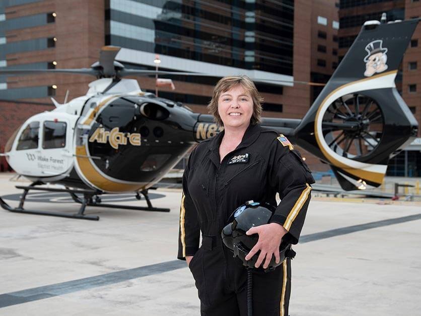 Wendy Rash standing next to a helicopter