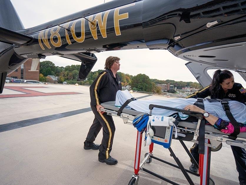 Wendy Rash loading a patient into a helicopter