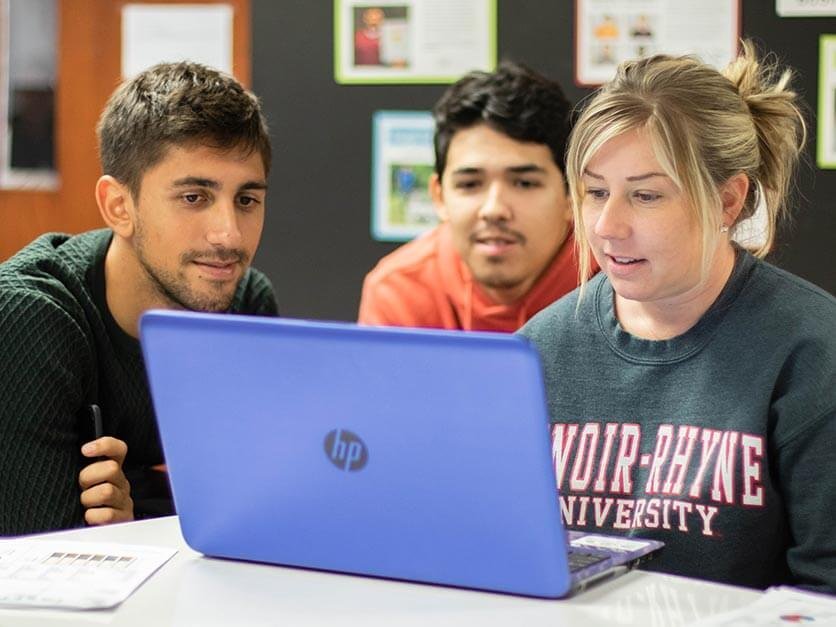 Students looking over an assignment on a computer