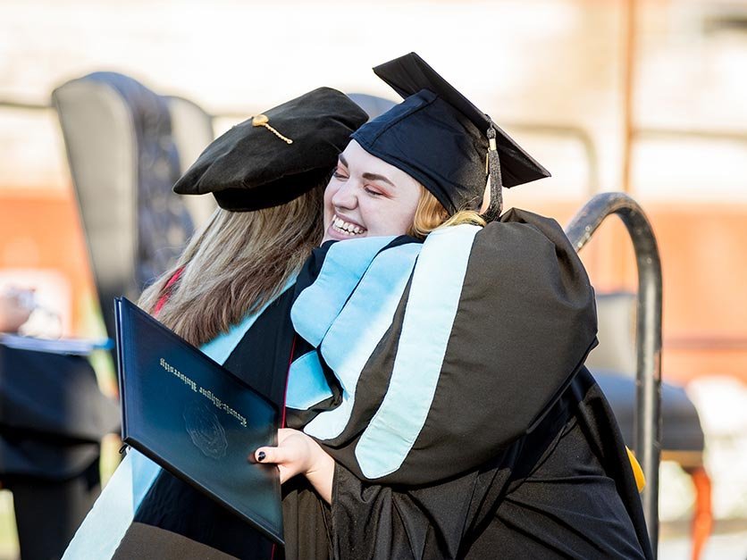 Graduating students hug