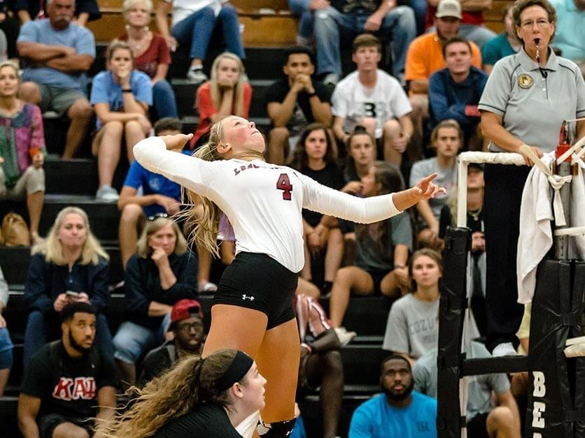 A volleyball player spikes the ball