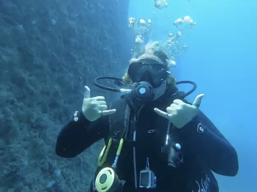Chrissy Elliot looks at the camera while scuba diving underwater 