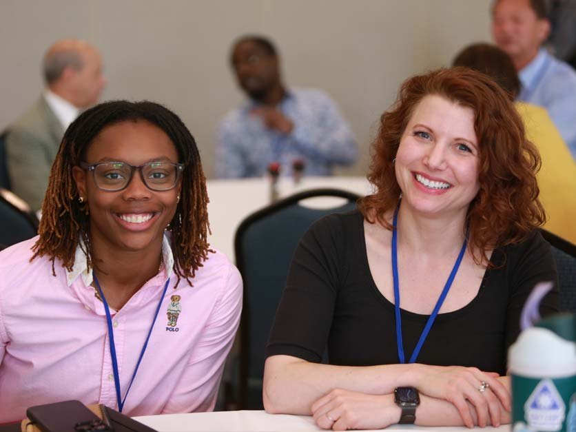 Professor Carly York and student at table during NCAS meeting