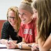 Group of smiling students working on class project at table