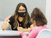 Geraldine Ledezma-Garcia works with an elementary student in classroom at table