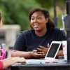 Two students talk at a table in Shaw Plaza