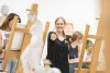 Claire Pope stands in an art classroom with students around her