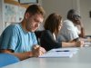 Seminary students writing at table in classroom