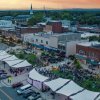 Aerial view of downtown Hickory at sunset with concert on the green by the Sails