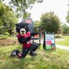 Joe Bear poses in front of the Bear Grove Big Chair and a welcome sign