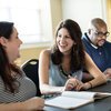 Three students talking in classroom
