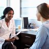 Nurse practitioner talks with patient during conversation in office