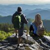 Two hikers view the scenic mountains from peak near Asheville, NC