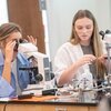 Two students working with microscopes during science lab