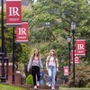 LR students walking along sidewalk on campus with LR banners in background