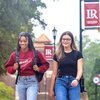 Two students walking on campus with LR banners in background