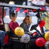 Summer McGee drives a golf cart decorated with red, black, and gold streamers and balloons