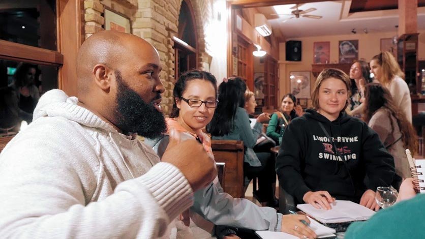 Group of LR study abroad students gather in cafe to discuss their experience