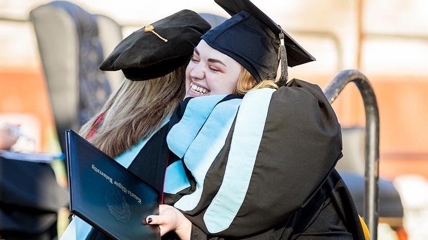 Graduating students hug