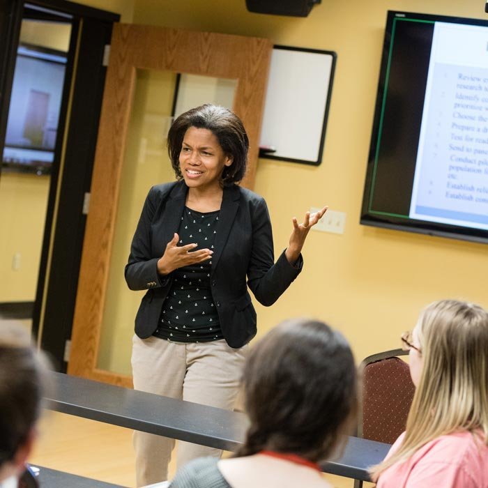 Professor delivers lecture in front of class