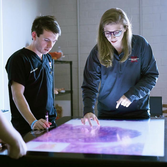 Students works with table-based tablet in classroom